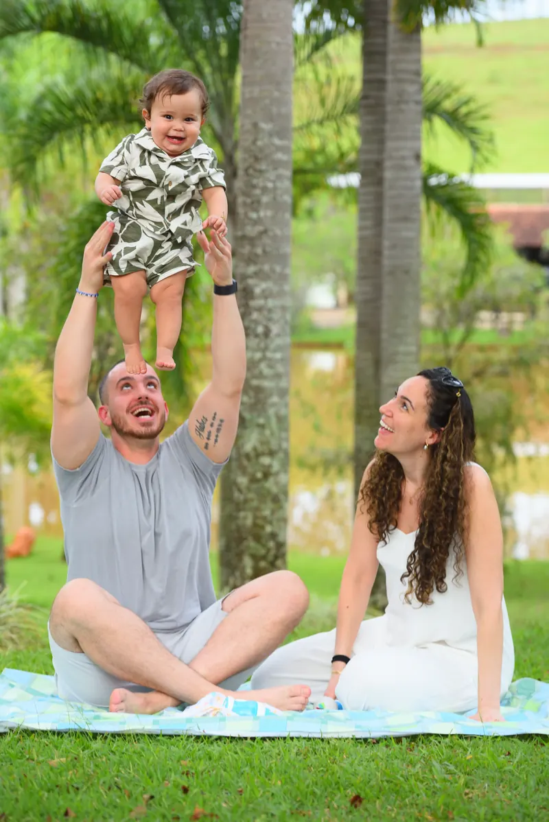Bebê no alto, nas mãos do pai