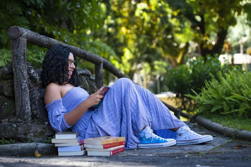 Debutante lendo no jardim, entre livros
