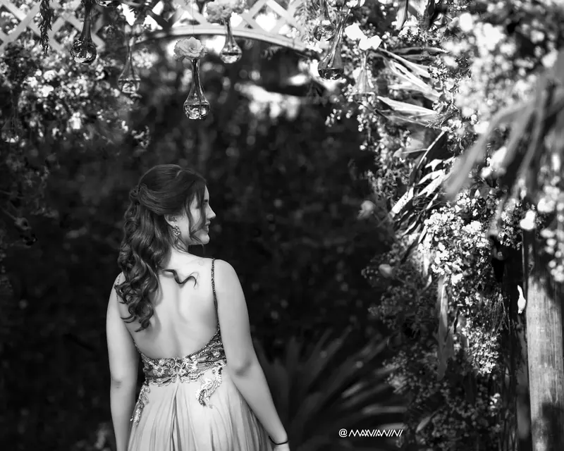 Debutante sob o arco de flores, em preto e branco